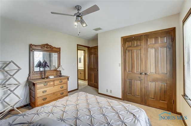 bedroom with light colored carpet, ceiling fan, and a closet