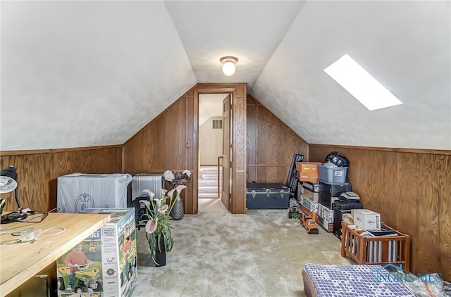 additional living space featuring light colored carpet, wooden walls, and lofted ceiling with skylight