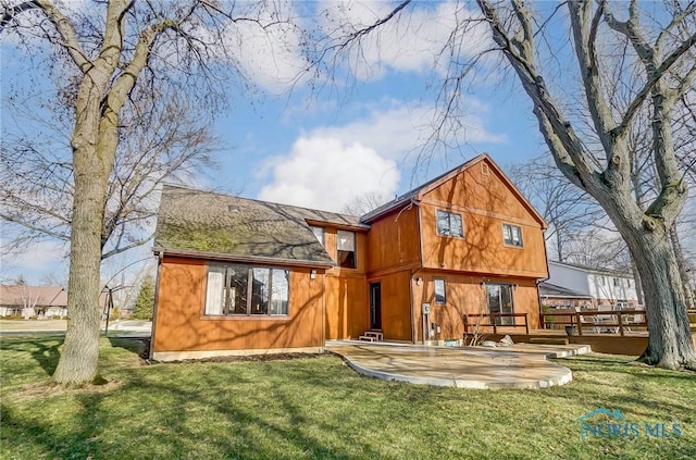 rear view of property featuring a yard and a patio