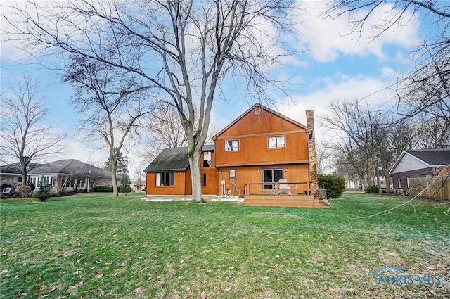 back of house with a wooden deck and a yard