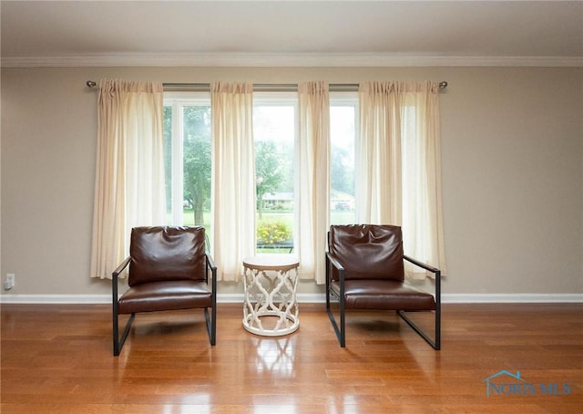 living area with ornamental molding and hardwood / wood-style floors