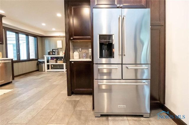 kitchen featuring tasteful backsplash, stainless steel appliances, and dark brown cabinets