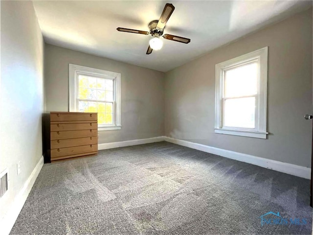 unfurnished room featuring ceiling fan and carpet