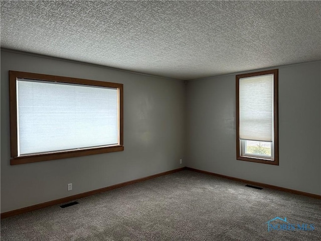 empty room with carpet and a textured ceiling