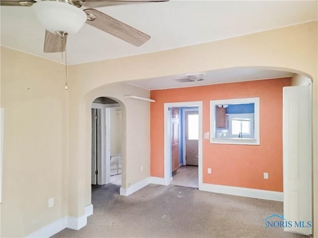 unfurnished room with ceiling fan and carpet