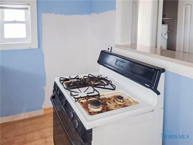 kitchen with white cabinetry, white gas stove, and light wood-type flooring