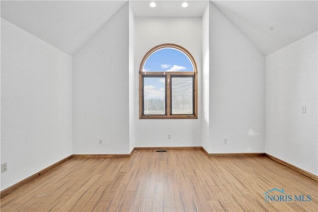 additional living space with lofted ceiling and light hardwood / wood-style flooring