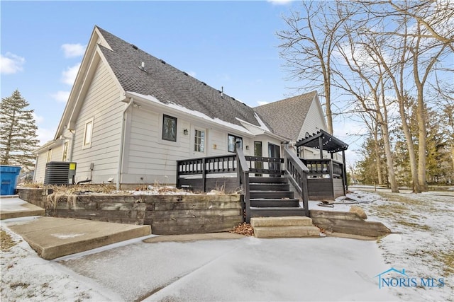 view of front of property featuring a deck, central air condition unit, and a pergola