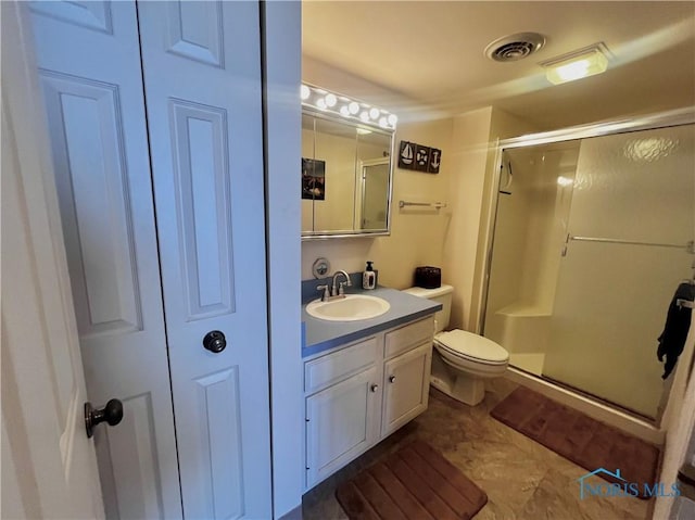 bathroom featuring vanity, an enclosed shower, and toilet