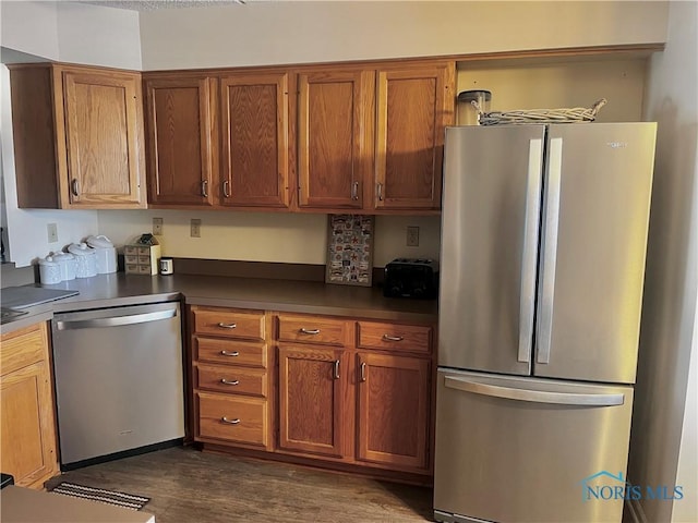 kitchen with appliances with stainless steel finishes and dark hardwood / wood-style floors