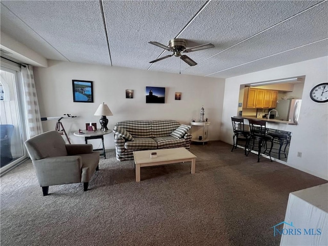 carpeted living room featuring sink, a textured ceiling, and ceiling fan