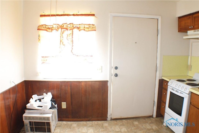 kitchen with electric range and wooden walls