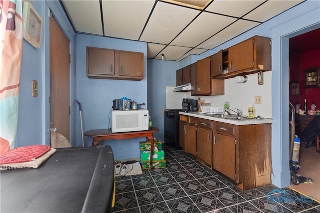 kitchen with a drop ceiling, sink, and black range