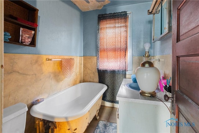 bathroom featuring tile walls, plenty of natural light, a tub, and toilet