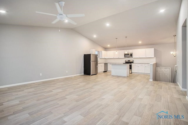 kitchen with white cabinetry, light wood-type flooring, a kitchen island, pendant lighting, and stainless steel appliances