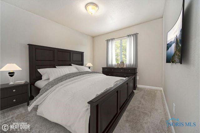 bedroom with baseboards and light colored carpet