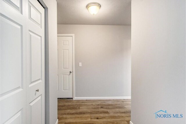 corridor featuring hardwood / wood-style floors and a textured ceiling