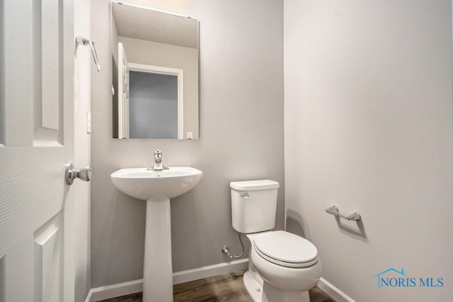 bathroom featuring wood-type flooring, sink, and toilet