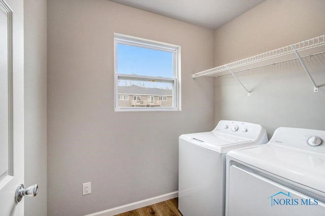 washroom featuring laundry area, baseboards, independent washer and dryer, and wood finished floors