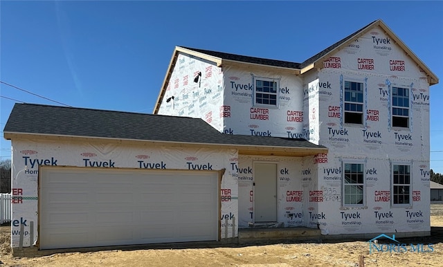 property under construction with an attached garage and a shingled roof