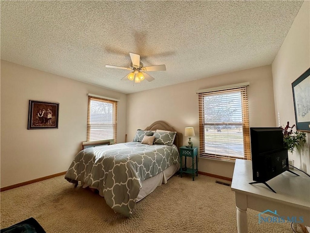 carpeted bedroom with a textured ceiling and ceiling fan