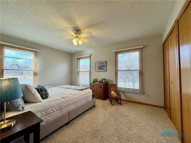 bedroom with light carpet, a textured ceiling, a closet, and ceiling fan