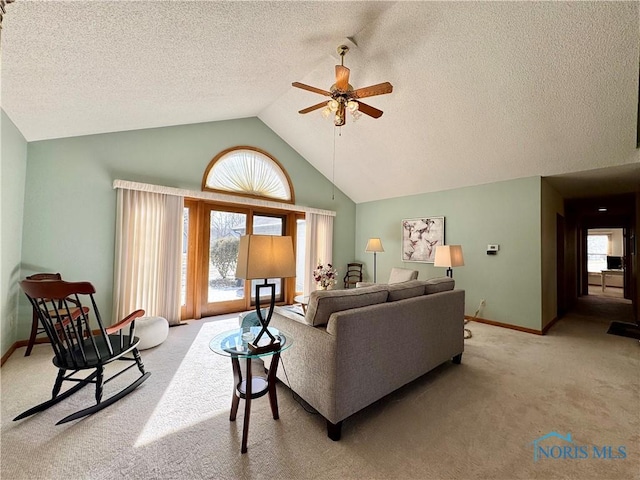 living room featuring ceiling fan, a healthy amount of sunlight, high vaulted ceiling, and carpet floors