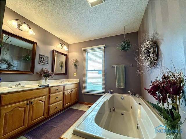 bathroom featuring vanity, a bath, and a textured ceiling