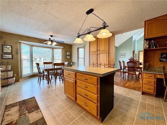 kitchen with pendant lighting, light tile patterned floors, a textured ceiling, and a kitchen island