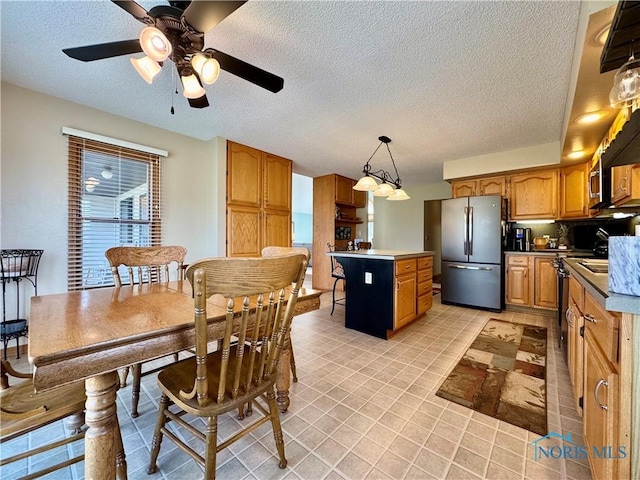 dining area featuring ceiling fan and a textured ceiling