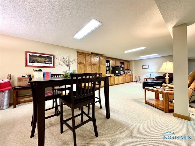 carpeted dining area with a textured ceiling