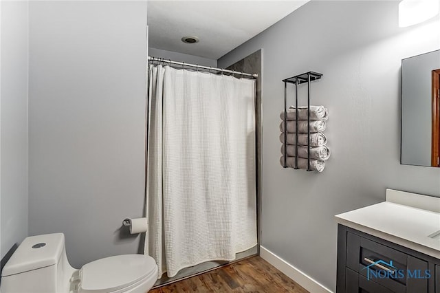 bathroom featuring hardwood / wood-style flooring, curtained shower, and toilet