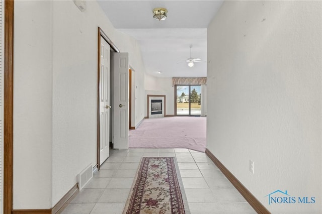 corridor featuring light tile patterned flooring and lofted ceiling