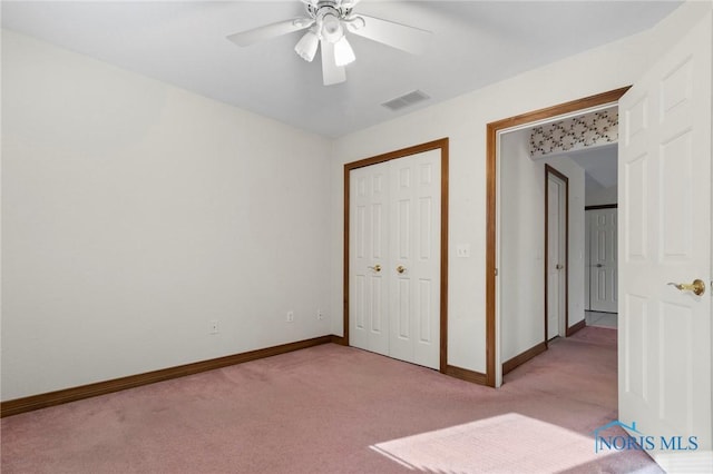 unfurnished bedroom with ceiling fan, a closet, and light carpet