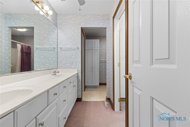 bathroom with vanity, ceiling fan, and walk in shower