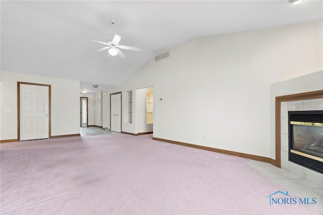 unfurnished living room featuring light carpet, high vaulted ceiling, a tile fireplace, and ceiling fan