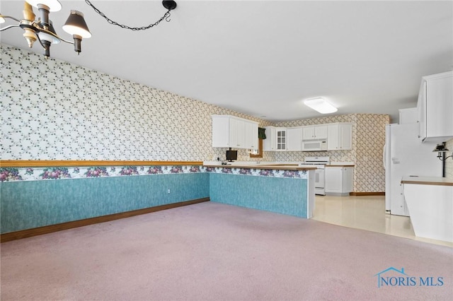 kitchen featuring white cabinetry, white appliances, light colored carpet, and a notable chandelier