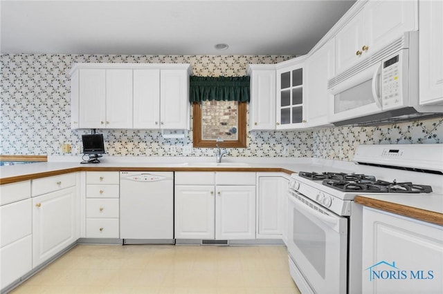 kitchen featuring white appliances, sink, and white cabinets