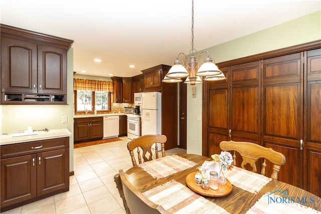 tiled dining space featuring a chandelier