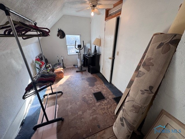 interior space featuring lofted ceiling, a textured ceiling, and ceiling fan