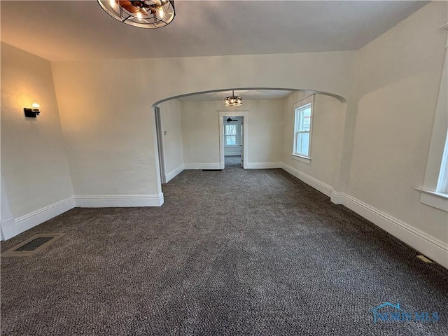 spare room featuring dark colored carpet