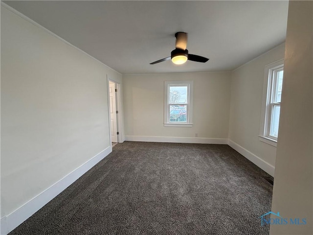 spare room with dark carpet and ceiling fan