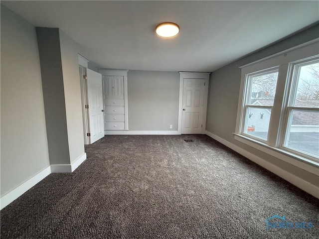 unfurnished bedroom featuring dark colored carpet