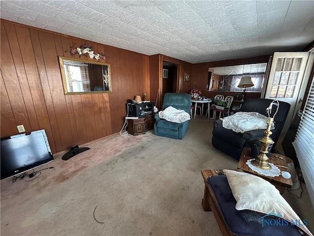 carpeted living room featuring wooden walls