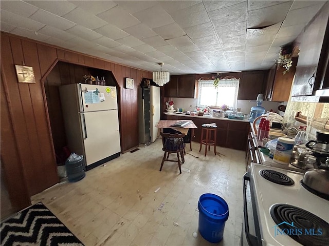 kitchen featuring white appliances and wood walls