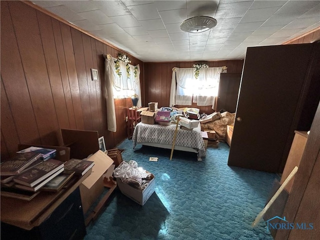 carpeted bedroom with wood walls