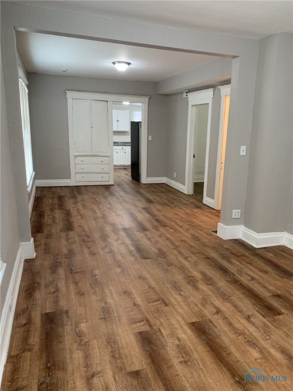 unfurnished living room featuring dark wood-type flooring