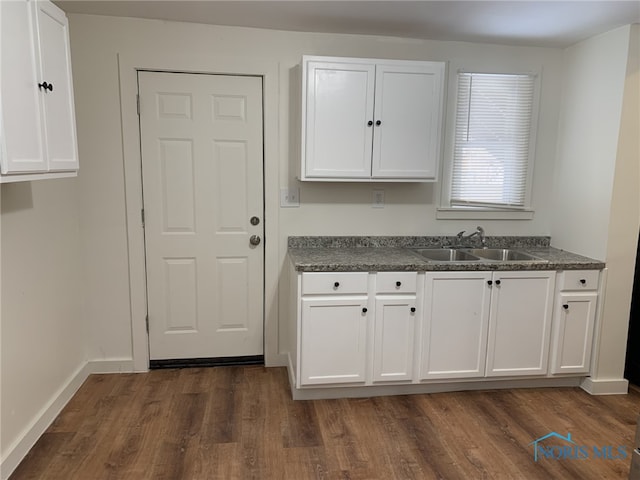 kitchen featuring white cabinetry, dark hardwood / wood-style flooring, and sink