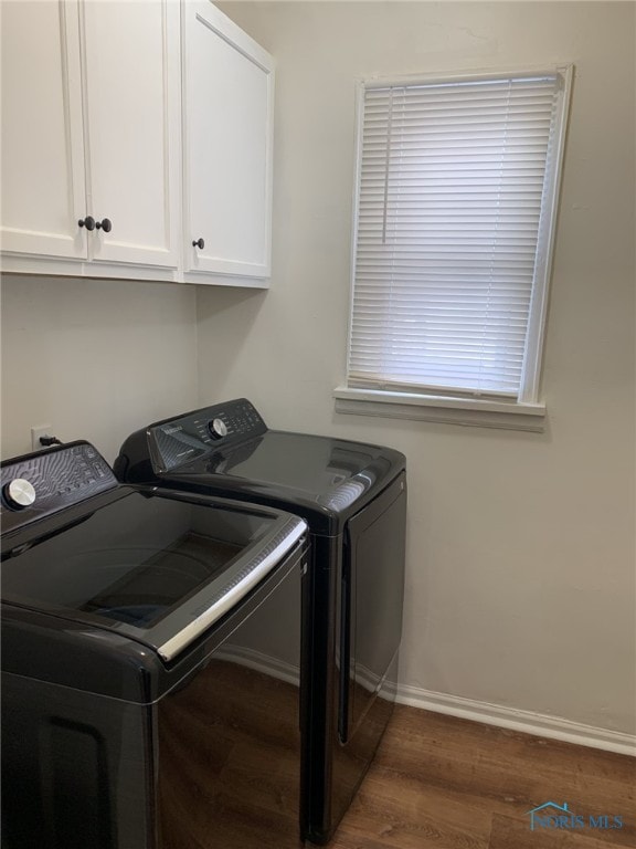 laundry room featuring cabinets, dark hardwood / wood-style floors, and independent washer and dryer