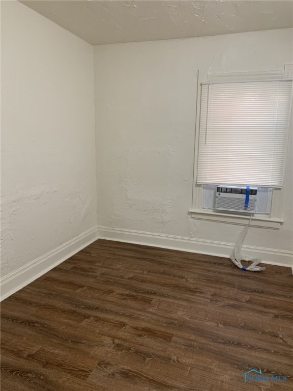 empty room with dark hardwood / wood-style floors and cooling unit